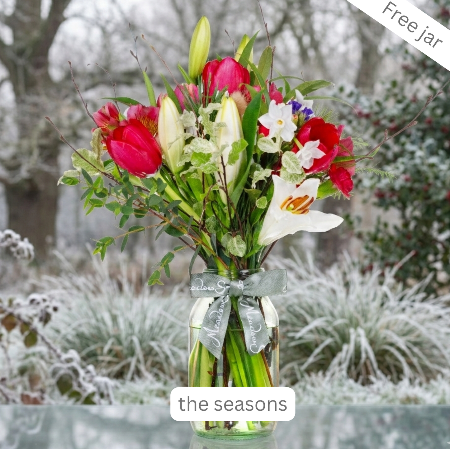 Bouquet of British-grown winter flowers and lilies in a glass jar in a frosty winter setting