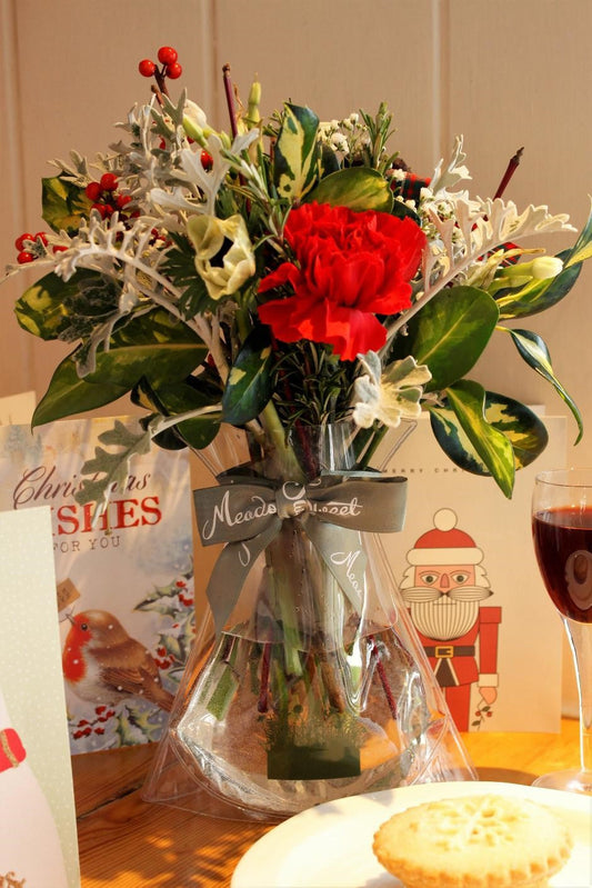 MeadowSweet seasonal posy with white anemones, red carnation, white narcissus, gypsophila, holly and ivy berries, red dogwood twigs, senecio, rosemary, pine, varigated holly.