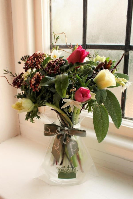 MeadowSweet seasonal posy with British pink and red tulips, paperwhite narcissi, manuka, alder catkins, pittosporum, pink viburnum buds, red hebe, twisted willow, ivy berries, red dogwood plus white 'panda' anemones thanks to Holland.