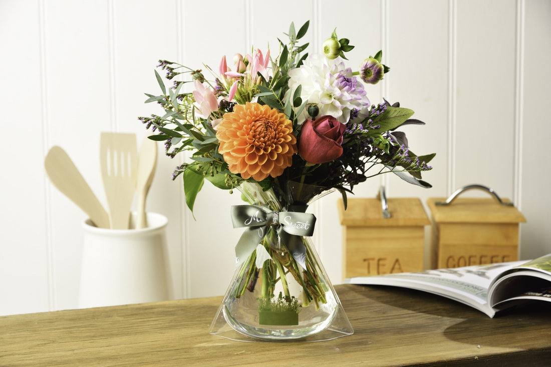 MeadowSweet seasonal posy with British dahlias arranged with a gorgeously scented British Pure Poetry rose, cleomie, hypericum, poppy seedheads, sea lavender and eucalyptus.