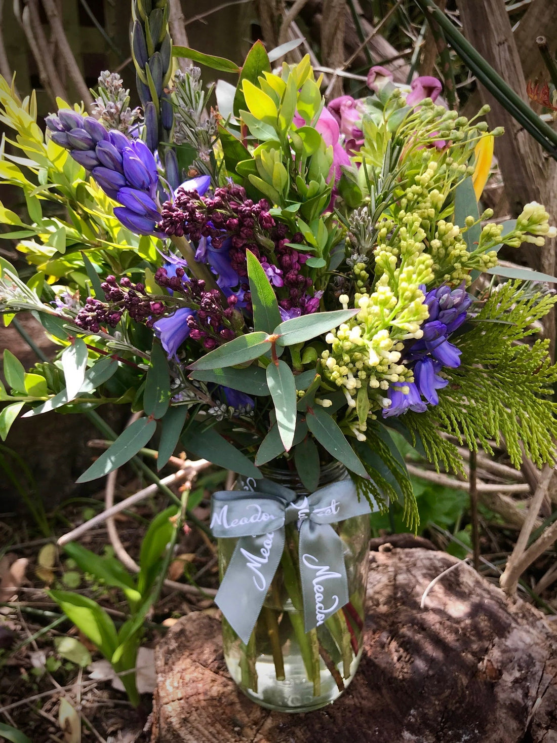 Beautiful and fragrant Homegrown lilac and blubells spring flowers in a glass jar
