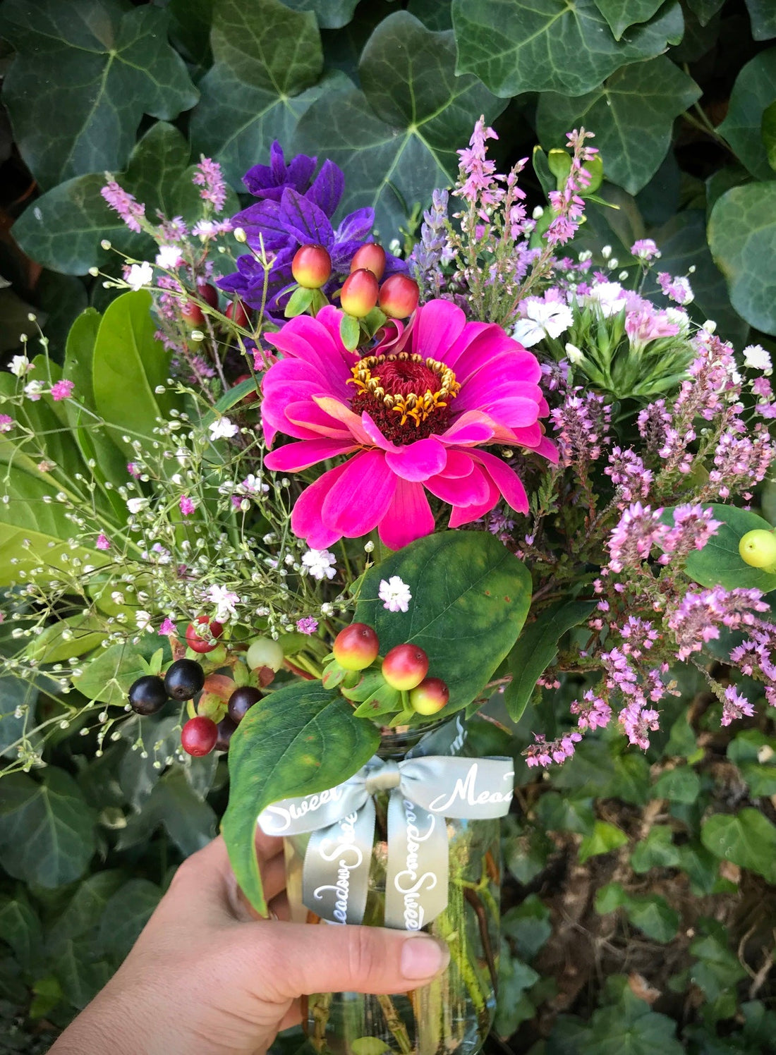 Zinnia, gypsophila and heather flower posy in a jar