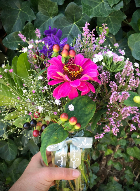 Zinnia, gypsophila and heather flower posy in a jar