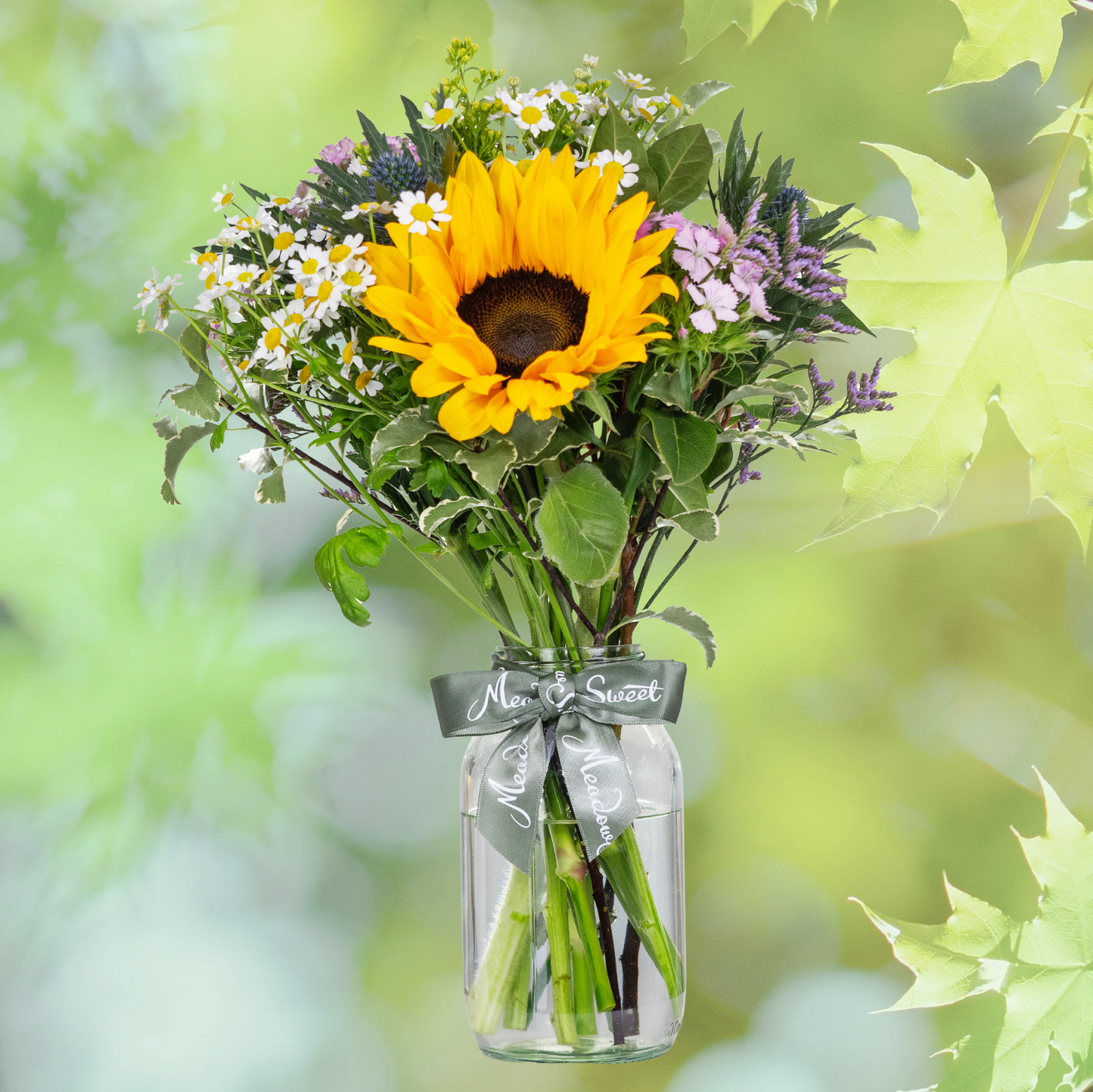 British Grown Summer Flower Posy with sunflower sweet williams and daisies In Glass Jar with Summer leaf backdrop