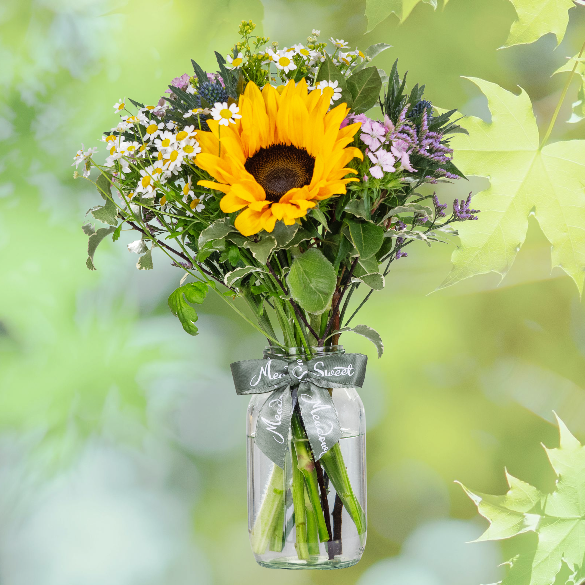 British Grown Summer Flower Posy with sunflower sweet williams and daisies In Glass Jar with Summer leaf backdrop