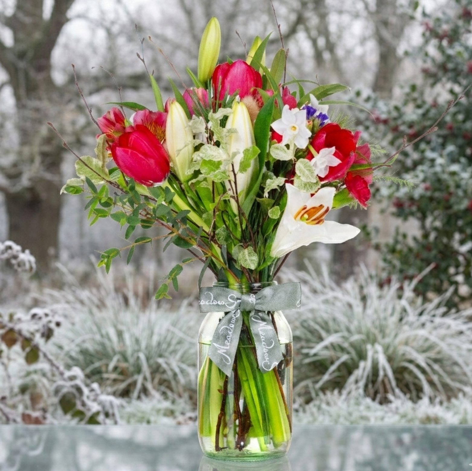 Bouquet of British grown winter flowers in a glass vase with a snowy background