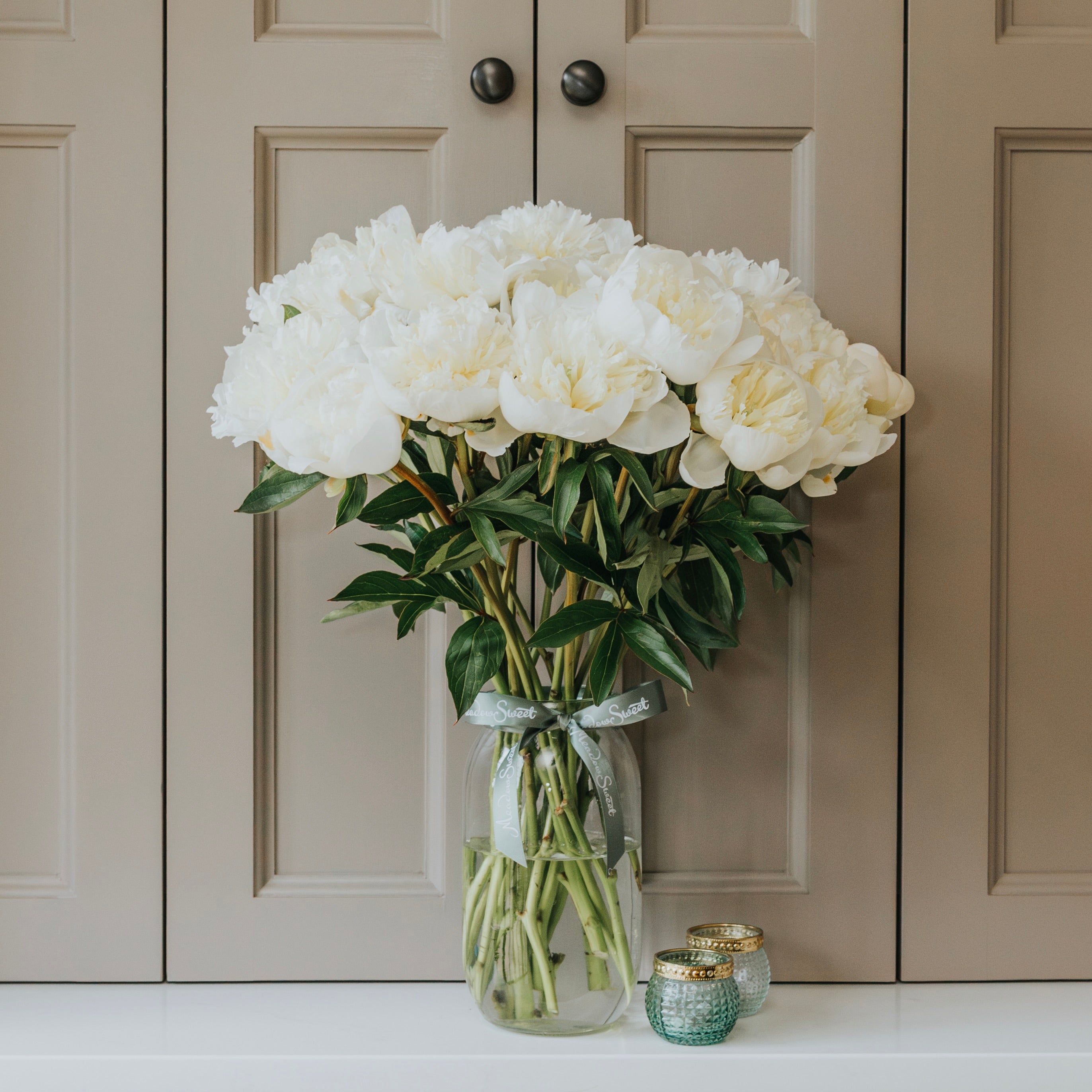 Quality long-stemmed British grown white peonies in tall glass jar flower subscription