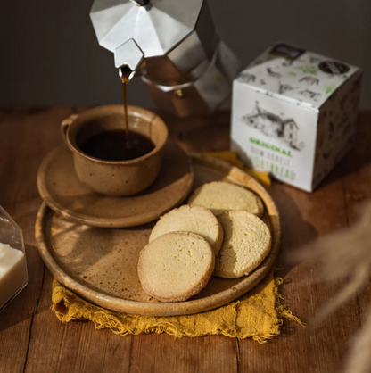 New Forest Shortbread biscuits on a rustic plate with shortbread gift box and a cup of coffee.